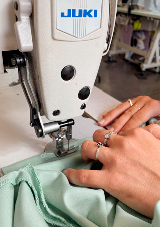 Gros plan sur des mains qui fabrique une blouse médicale - étape couture